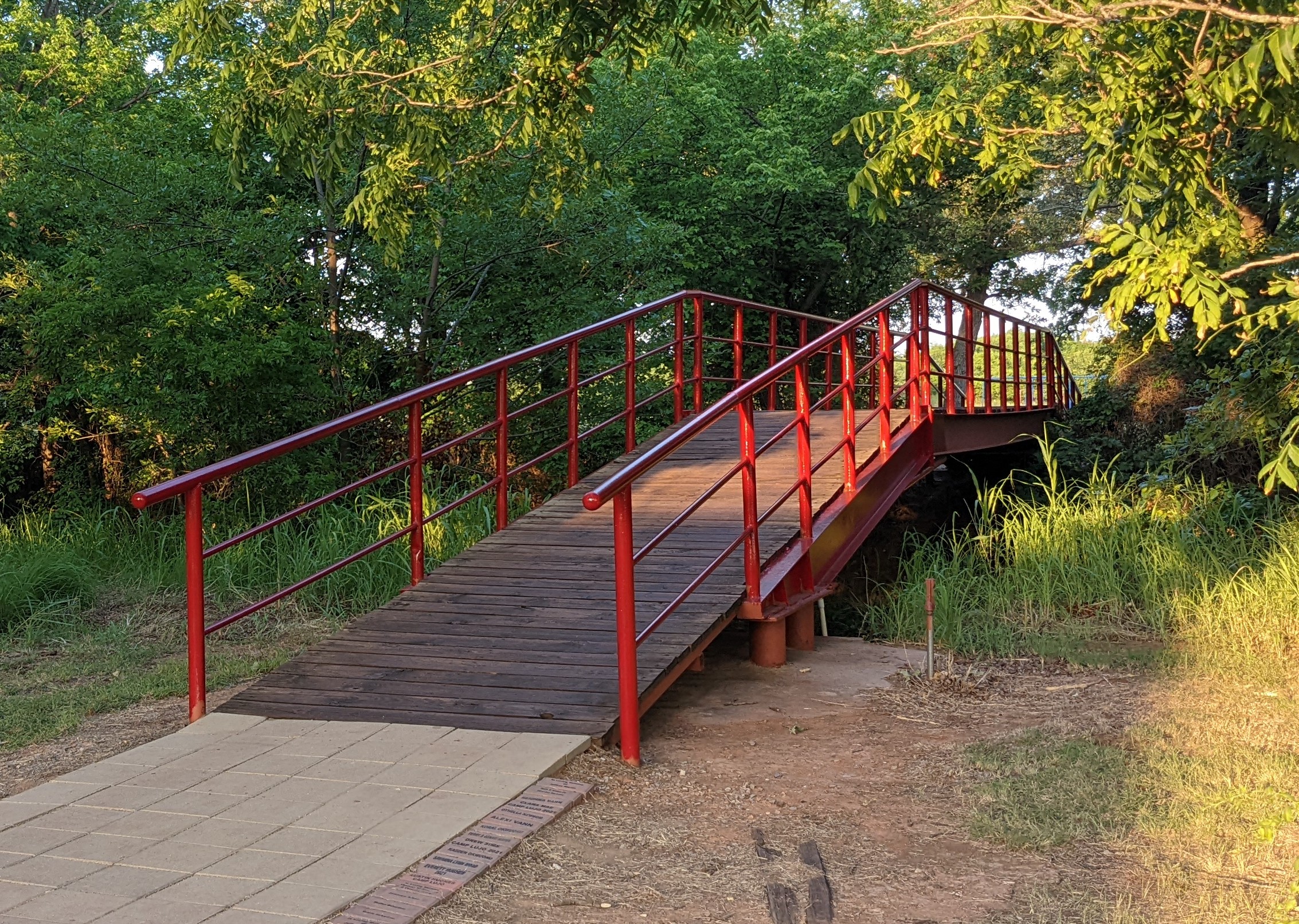 Campers walking across a wooden bridge in the forest